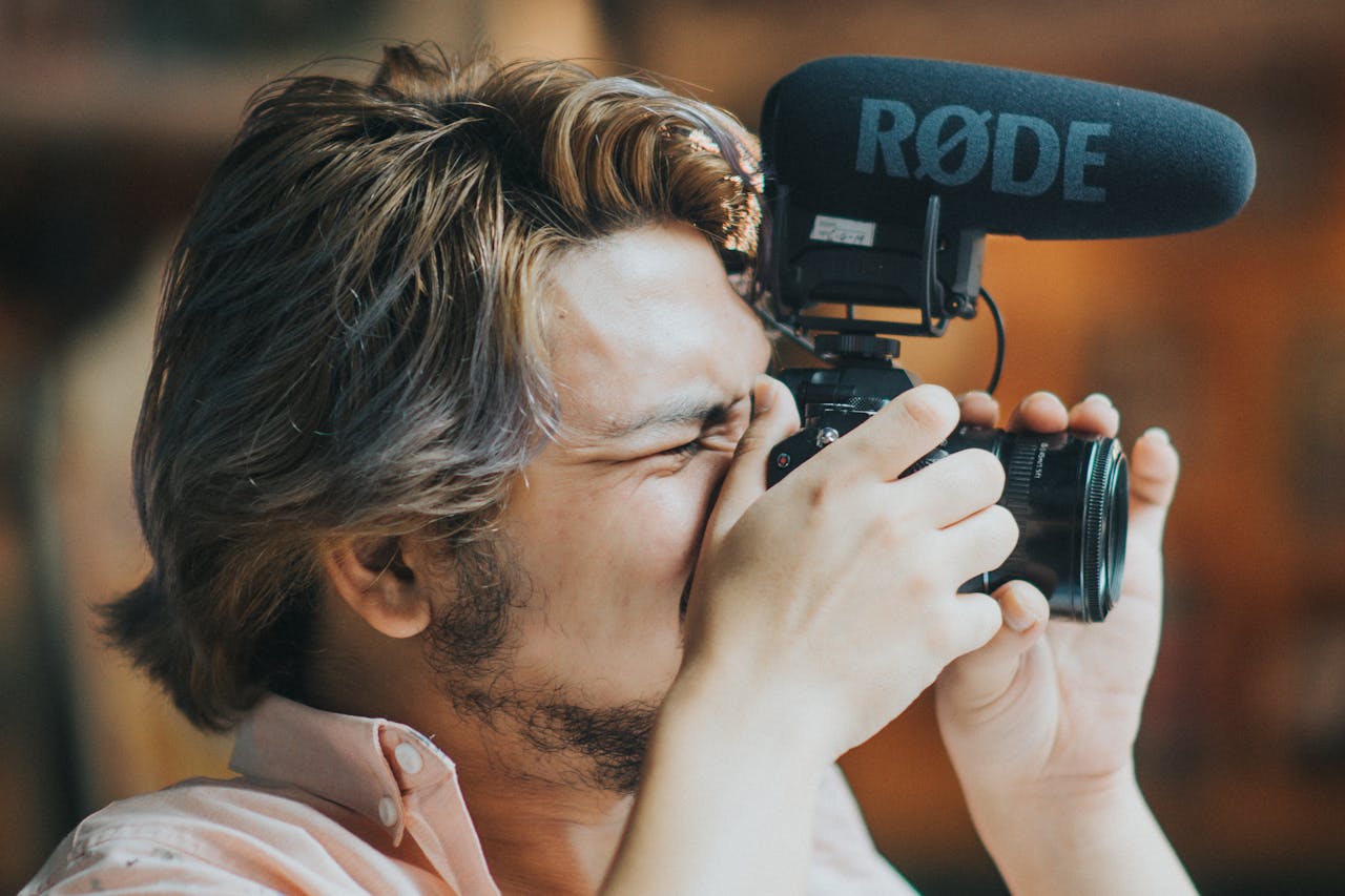 A professional focuses on photography with a mounted microphone, showcasing concentration and creativity.