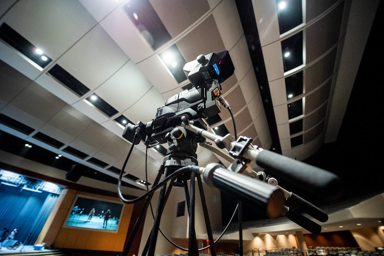 menu-04 Professional video camera setup in a theater capturing a performance, showcasing modern filming technology.